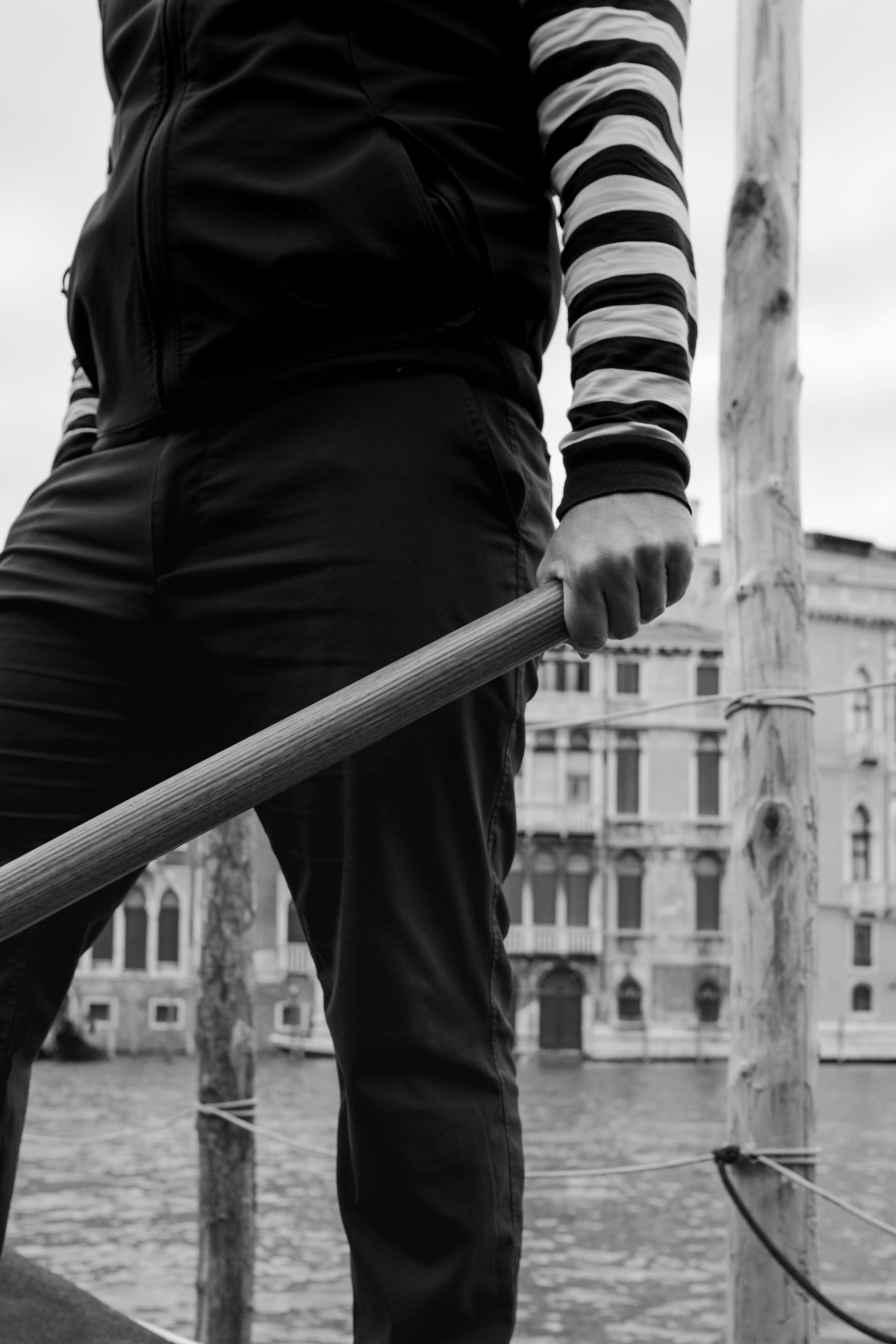 person in black and white long sleeve shirt and black pants standing on bridge